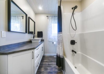 A well-appointed bathroom showcasing a sink and two elegant mirrors, enhancing the space's aesthetic appeal.